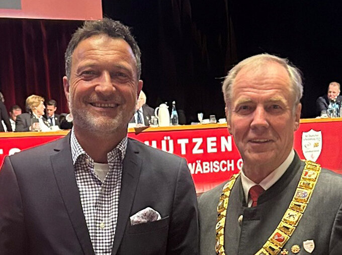 Matthias Klotz, Vorsitzender des Bundesverbands zivile Legalwaffen e. V. (BZL), gemeinsam mit Hans-Heinrich von Schönfels, altem und neuem Präsidenten des Deutschen Schützenbundes (DSB), bei einer Veranstaltung; im Hintergrund ein Sitzungssaal mit Banner des Schützenwesens.