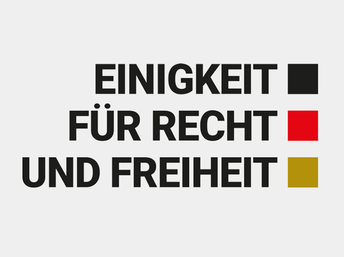 Grafik mit dem Schriftzug „Einigkeit für Recht und Freiheit“ in schwarzer Typografie, daneben drei farbige Quadrate in Schwarz, Rot und Gold.