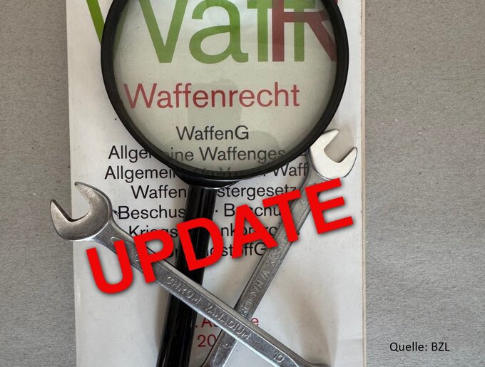 Eine Lupe und zwei gekreuzte Schraubenschlüssel liegen auf einem Dokument zum Waffenrecht. Darüber steht in roter Schrift das Wort „UPDATE“.
