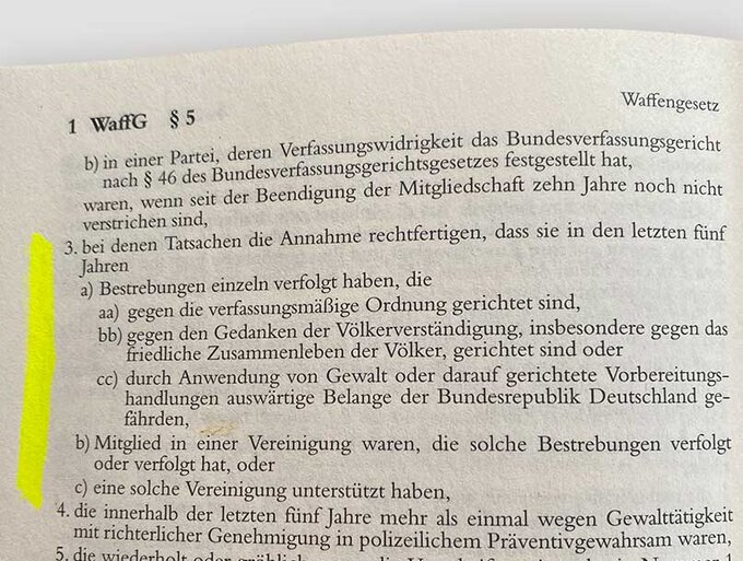 Abfotografierte Buchseite aus dem Waffengesetz (§ 5 WaffG) mit markiertem Rand; gedruckter Gesetzestext zur waffenrechtlichen Zuverlässigkeit und zu verfassungsfeindlichen Bestrebungen, Überschrift „WaffG § 5“ oben sichtbar.