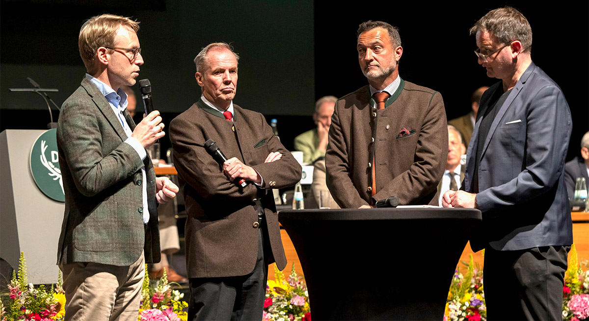Podiumsdiskussion zum Waffenrecht: Von links Marc Henrichmann (CDU), Hans-Heinrich von Schönfels (Deutscher Schützenbund, DSB) und Matthias Klotz (Bundesverband zivile Legalwaffen e. V., BZL) beantworten Fragen auf einer Bühne; Quelle: Wildgeflüster/DJV.