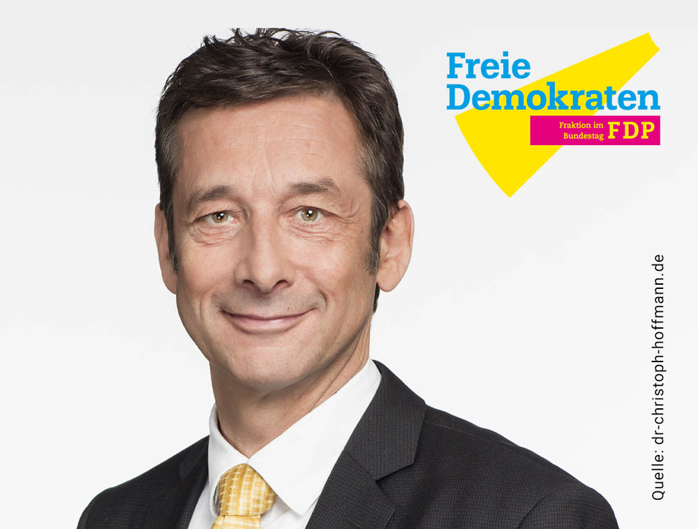 Porträt eines Mannes im Anzug mit gelber Krawatte vor hellem Hintergrund; rechts daneben das Logo „Freie Demokraten – Fraktion im Bundestag (FDP)“ sowie eine Quellenangabe am Bildrand.