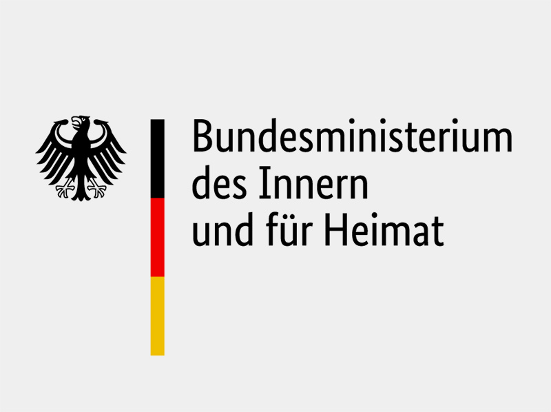 Logo des Bundesministeriums des Innern und für Heimat mit Bundesadler sowie vertikalem Farbbalken in Schwarz, Rot und Gold.